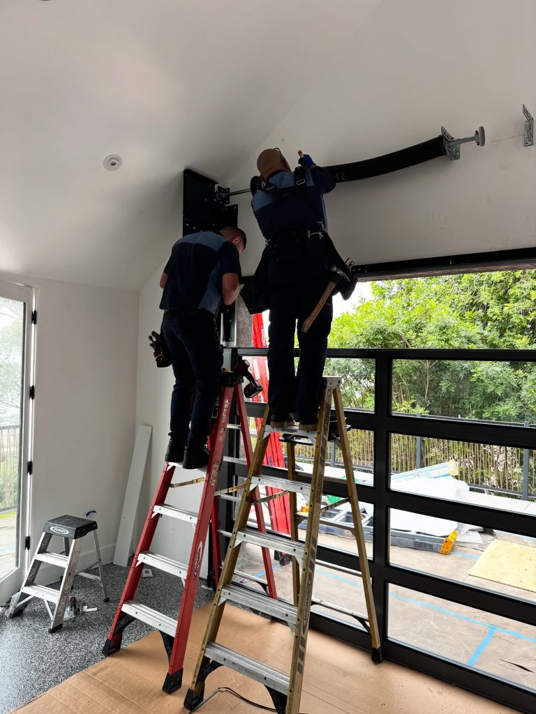 Two technicians installing overhead garage track