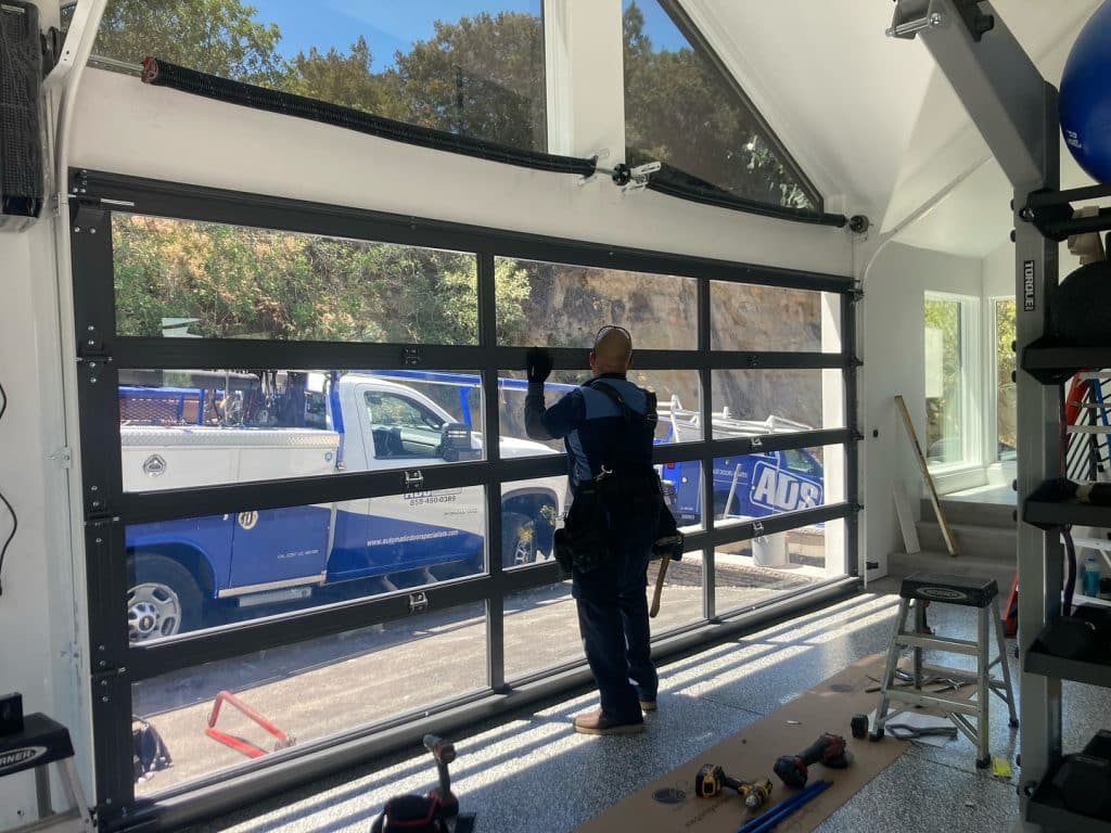 Technician installing full-view glass garage door